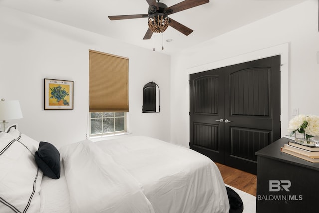 bedroom with hardwood / wood-style floors, ceiling fan, and a closet