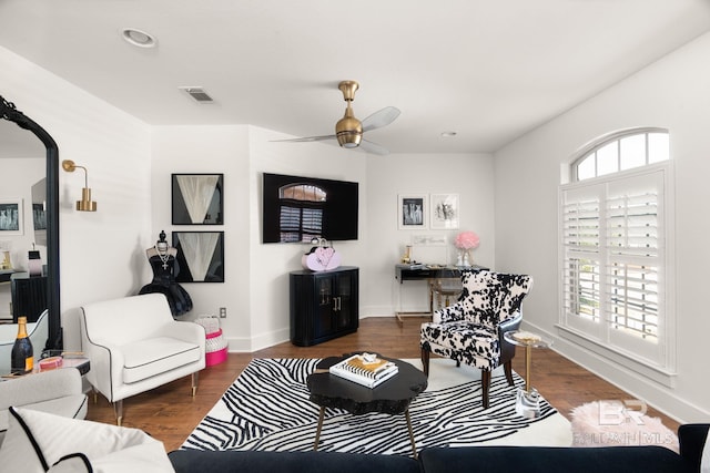 living room featuring a healthy amount of sunlight, dark wood-type flooring, and ceiling fan