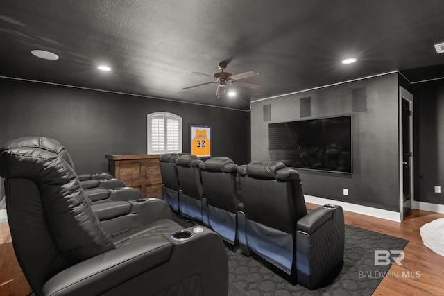 cinema with hardwood / wood-style flooring, a textured ceiling, and ceiling fan