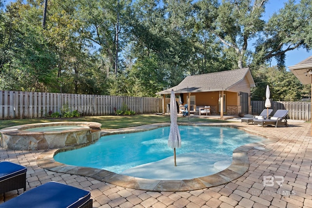 view of swimming pool with an in ground hot tub, an outbuilding, and a patio