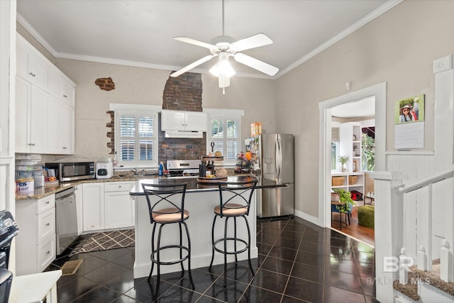20 Hurlbert St, Mobile, AL 36607 - kitchen featuring appliances with stainless steel finishes, under cabinet range hood, white cabinetry, ornamental molding, and a ceiling fan