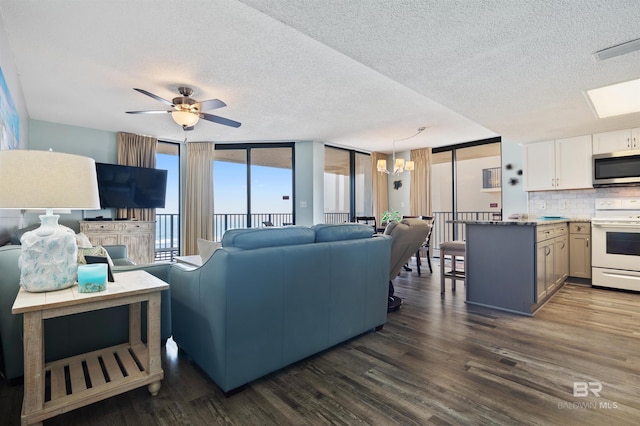 24400 Perdido Beach Blvd Unit 701, Orange Beach, AL 36561 - living area featuring dark wood-type flooring, a textured ceiling, and ceiling fan with notable chandelier