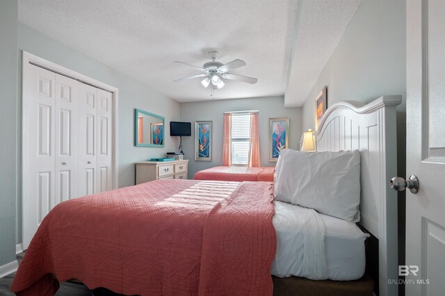 24400 Perdido Beach Blvd Unit 701, Orange Beach, AL 36561 - bedroom featuring a textured ceiling, a closet, and a ceiling fan