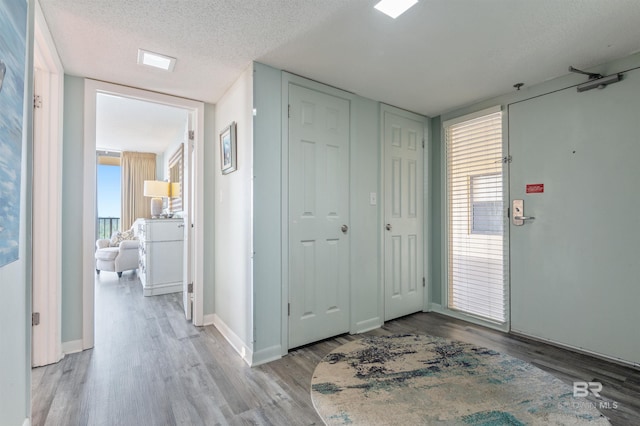 24400 Perdido Beach Blvd Unit 701, Orange Beach, AL 36561 - foyer featuring baseboards, light wood finished floors, and a textured ceiling