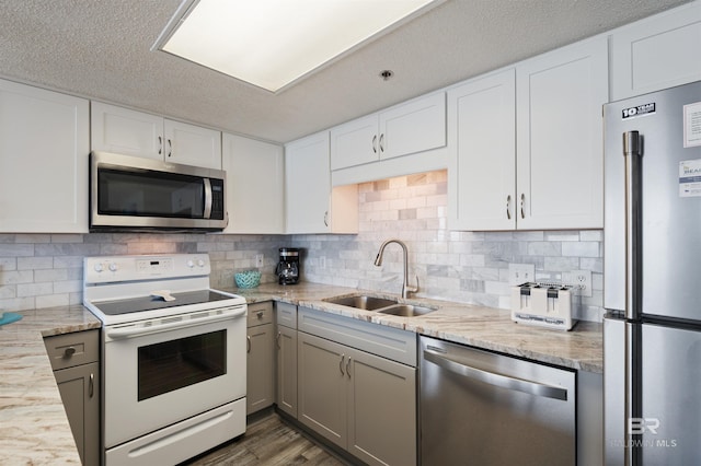 24400 Perdido Beach Blvd Unit 701, Orange Beach, AL 36561 - kitchen featuring tasteful backsplash, a sink, white cabinets, and stainless steel appliances