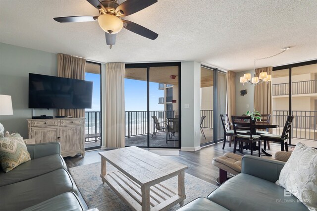 24400 Perdido Beach Blvd Unit 701, Orange Beach, AL 36561 - living area with ceiling fan with notable chandelier, a textured ceiling, floor to ceiling windows, wood finished floors, and baseboards