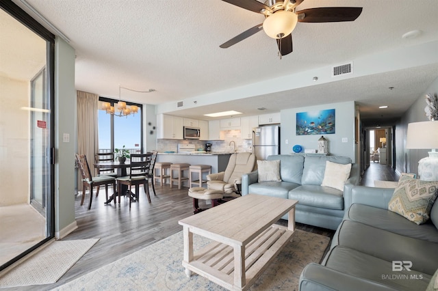 24400 Perdido Beach Blvd Unit 701, Orange Beach, AL 36561 - living room with a textured ceiling, ceiling fan with notable chandelier, light wood finished floors, and visible vents