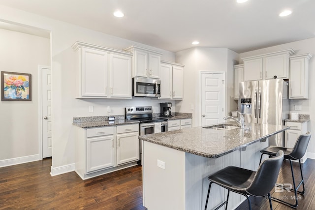 9393 Impala Dr, Foley, AL 36535 - kitchen featuring a sink, appliances with stainless steel finishes, a kitchen breakfast bar, white cabinetry, and dark wood-style flooring