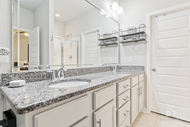 9393 Impala Dr, Foley, AL 36535 - bathroom featuring tile patterned floors, double vanity, a stall shower, and a sink