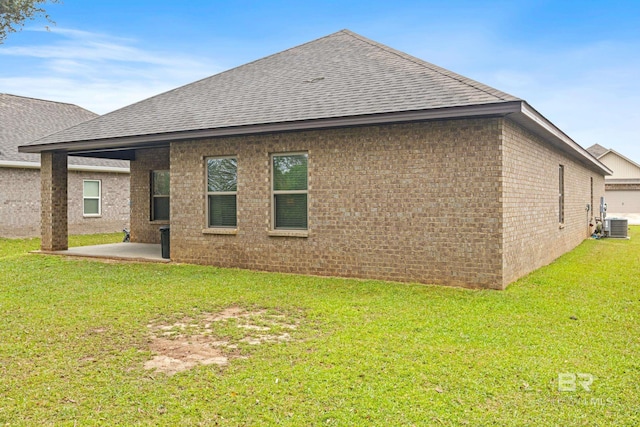 9393 Impala Dr, Foley, AL 36535 - back of property with brick siding, roof with shingles, a lawn, cooling unit, and a patio area