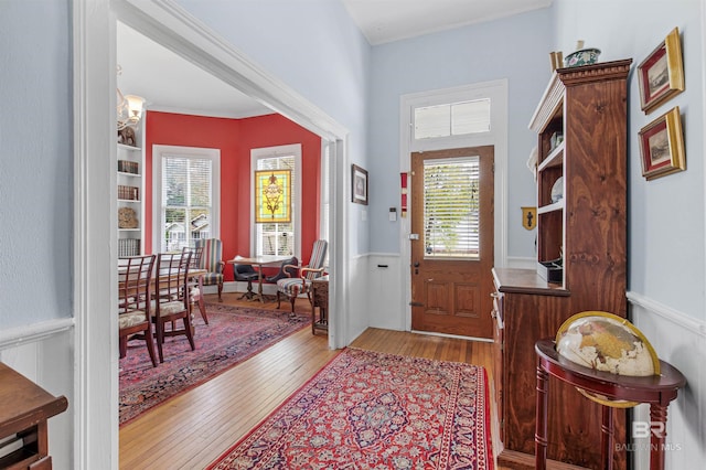 entrance foyer featuring light wood-style flooring and crown molding