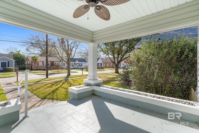 unfurnished sunroom featuring a residential view and ceiling fan