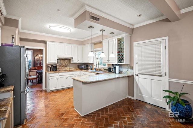 kitchen with kitchen peninsula, decorative light fixtures, stainless steel appliances, and a wealth of natural light