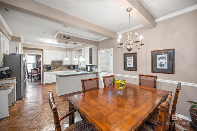 dining space featuring crown molding and a notable chandelier