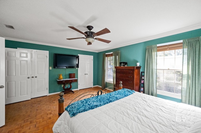 bedroom with ceiling fan, crown molding, a textured ceiling, and parquet floors