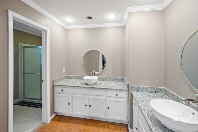 bathroom featuring vanity, crown molding, a textured ceiling, and walk in shower