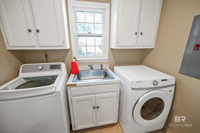 washroom featuring sink, washer and clothes dryer, electric panel, and cabinets