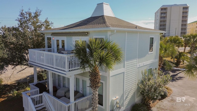 back of property with french doors and a balcony