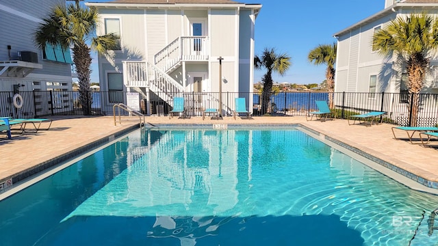 view of swimming pool featuring a patio and central air condition unit