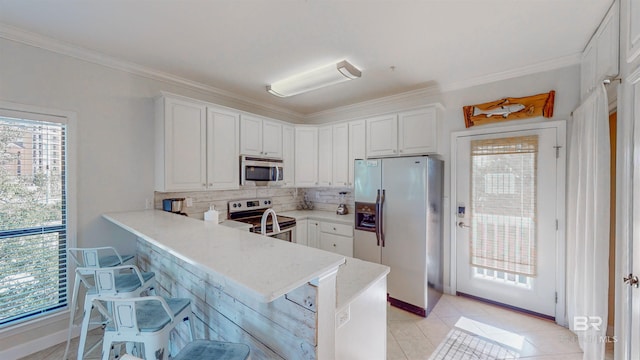 kitchen featuring white cabinetry, stainless steel appliances, and kitchen peninsula