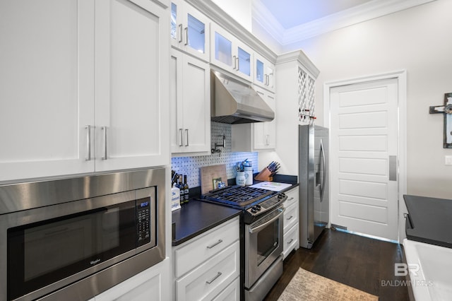 kitchen featuring white cabinetry, tasteful backsplash, dark hardwood / wood-style flooring, crown molding, and appliances with stainless steel finishes