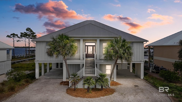 view of front facade featuring a carport, a porch, and a water view