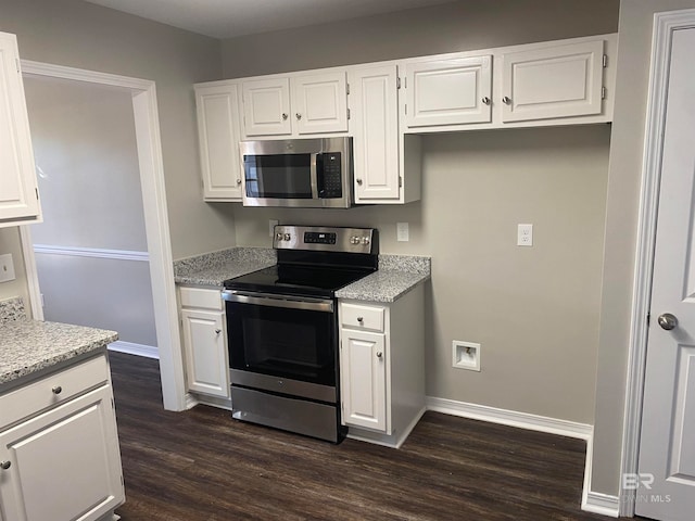 kitchen with white cabinetry, stainless steel appliances, and dark hardwood / wood-style floors