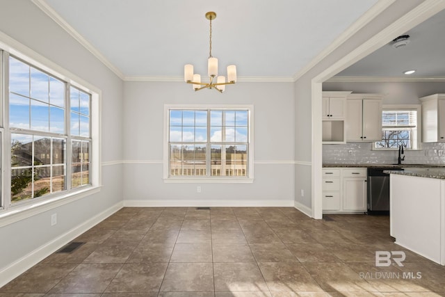 kitchen with backsplash, an inviting chandelier, white cabinets, dishwasher, and baseboards