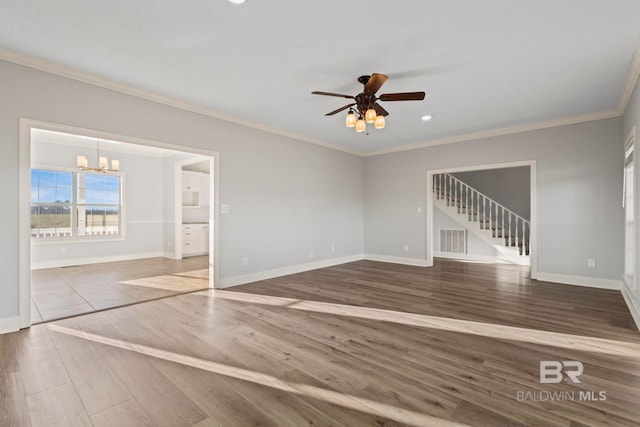 unfurnished living room with baseboards, visible vents, wood finished floors, and ornamental molding