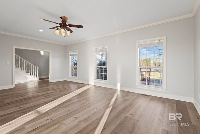 unfurnished living room featuring visible vents, crown molding, baseboards, and wood finished floors