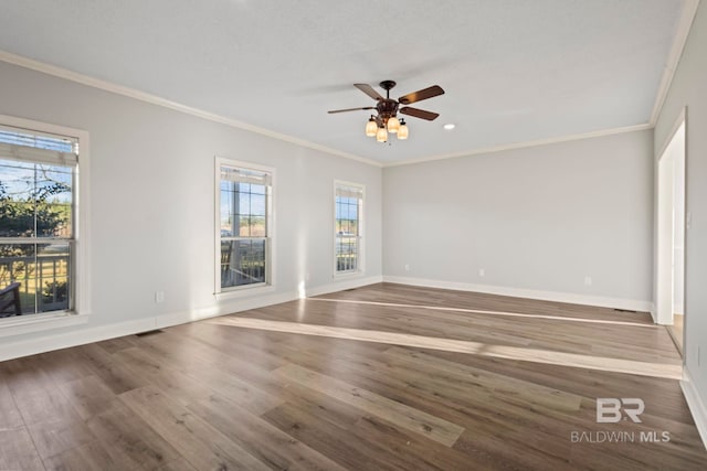 empty room with baseboards, wood finished floors, and ornamental molding