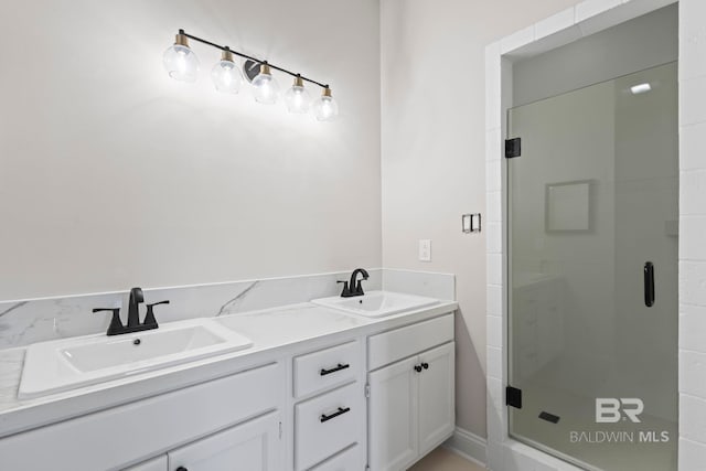 full bathroom featuring a stall shower, a sink, and double vanity