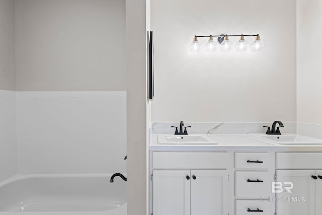 full bathroom featuring double vanity, a tub, and a sink