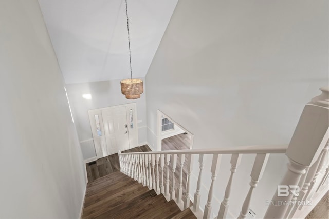 stairs with high vaulted ceiling, visible vents, and wood finished floors