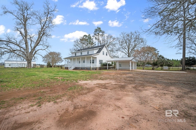 exterior space featuring driveway, covered porch, fence, and a front lawn