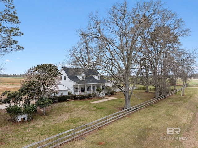 view of front of house featuring a rural view, a porch, a fenced front yard, and a front yard