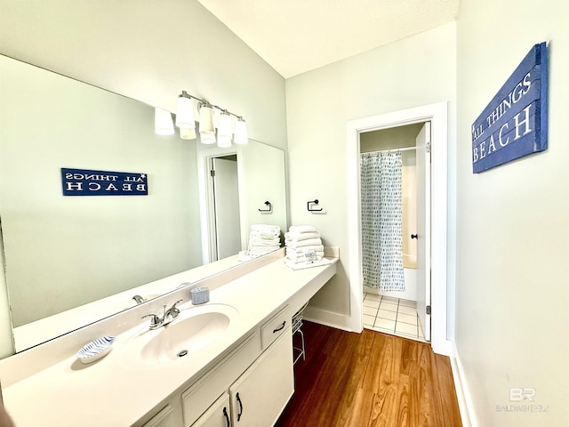 bathroom with a shower with curtain, wood finished floors, vanity, and baseboards