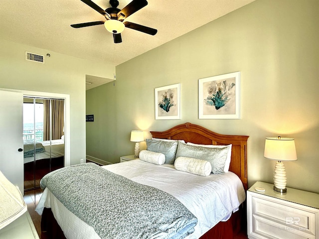 bedroom with a textured ceiling, visible vents, ceiling fan, a closet, and wood finished floors