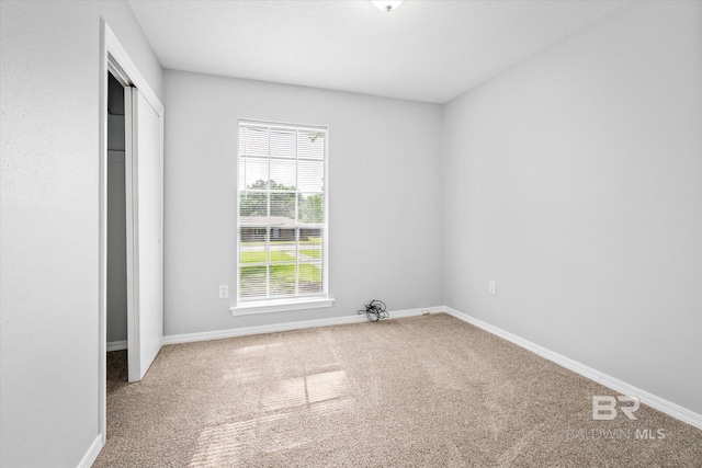 unfurnished bedroom featuring carpet floors and a closet