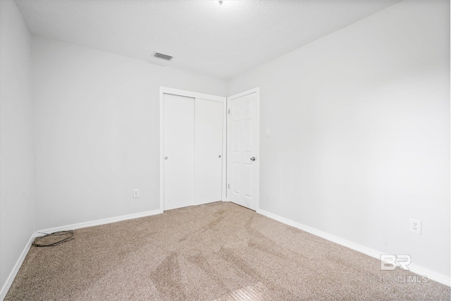 spare room with carpet flooring and a textured ceiling