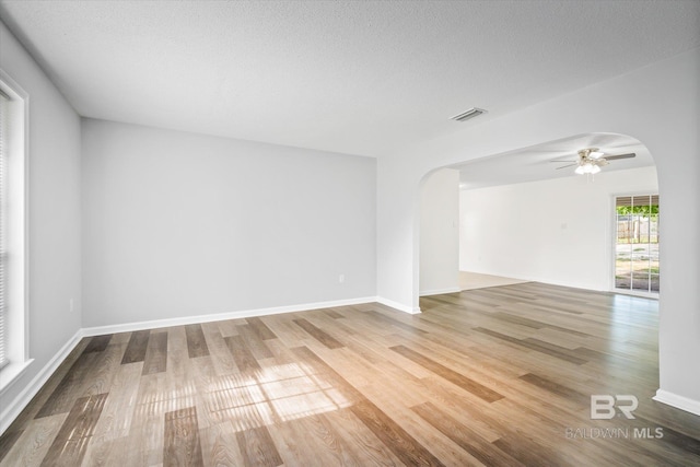 spare room with ceiling fan, wood-type flooring, and a textured ceiling