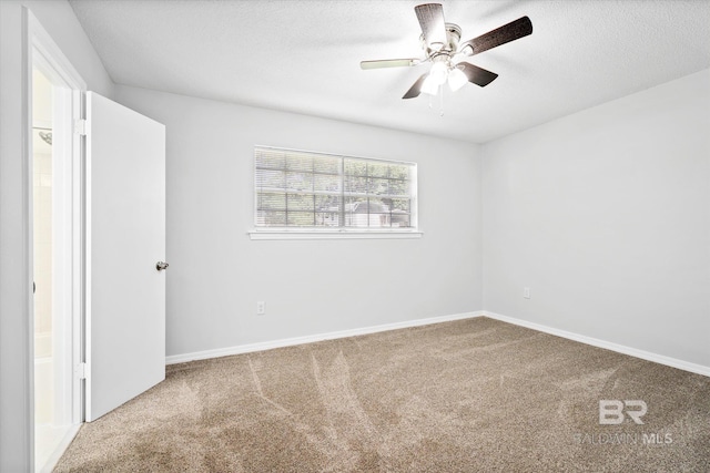 carpeted spare room featuring ceiling fan and a textured ceiling