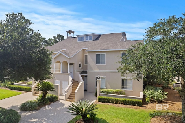 view of front of property with a shingled roof and stucco siding