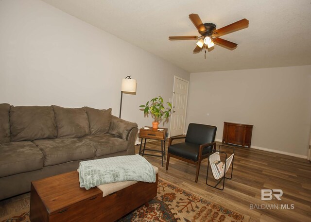 living room featuring ceiling fan and dark hardwood / wood-style flooring