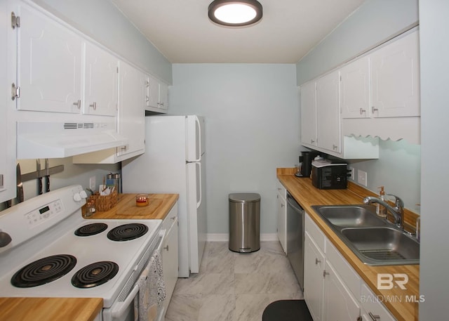 kitchen featuring stove, sink, custom range hood, and white cabinetry