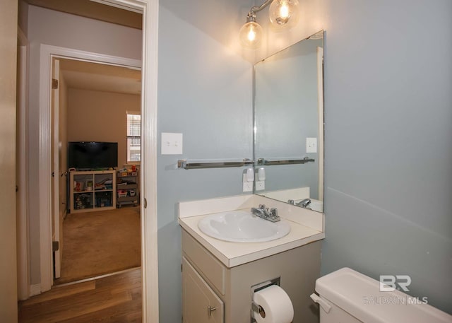 bathroom featuring wood-type flooring, vanity, and toilet