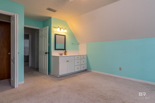 bathroom with lofted ceiling, visible vents, carpet flooring, vanity, and baseboards