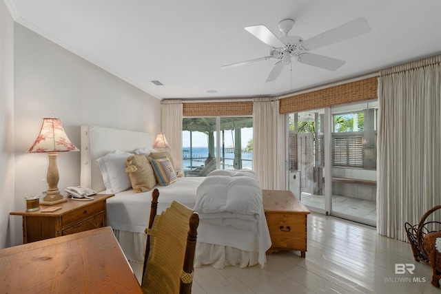 bedroom with access to outside, light wood-type flooring, ceiling fan, a water view, and crown molding