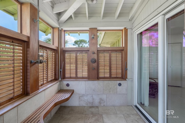 unfurnished sunroom featuring beamed ceiling