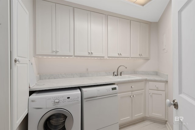 washroom with washer / dryer, cabinets, and sink